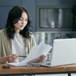 Personne consultant son dossier d'aide sociale sur ordinateur portable à domicile