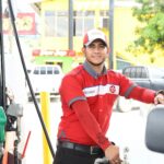 Pompe à essence en station-service, conducteur au volant en arrière-plan