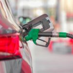 Automobiliste faisant le plein à une station-service en France, prix carburant affiché