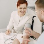 Aide à domicile accompagnant une personne âgée dans son salon, secteur médico-social