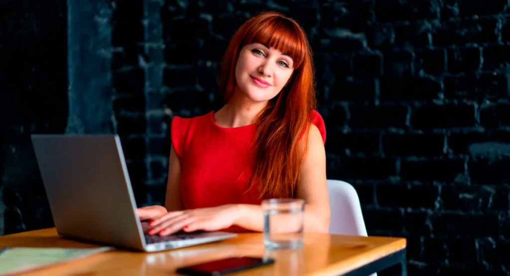 Rédactrice concentrée sur écran avec tableau SEO, ambiance formation acquisition