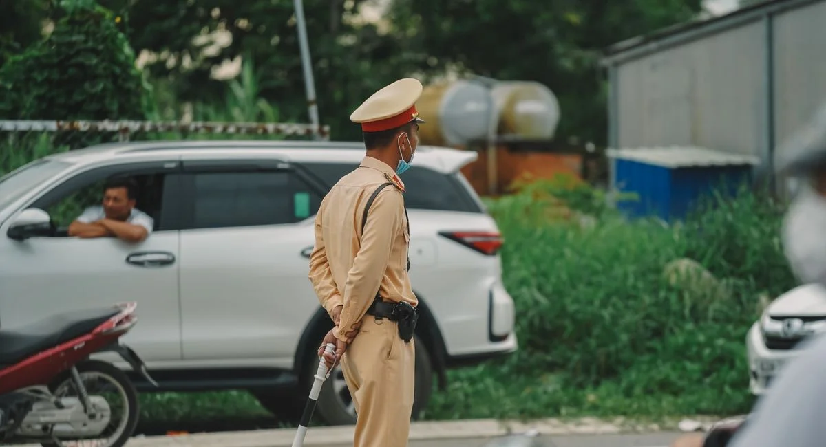 Traffic officer managing road with vehicles in an urban outdoor setting.